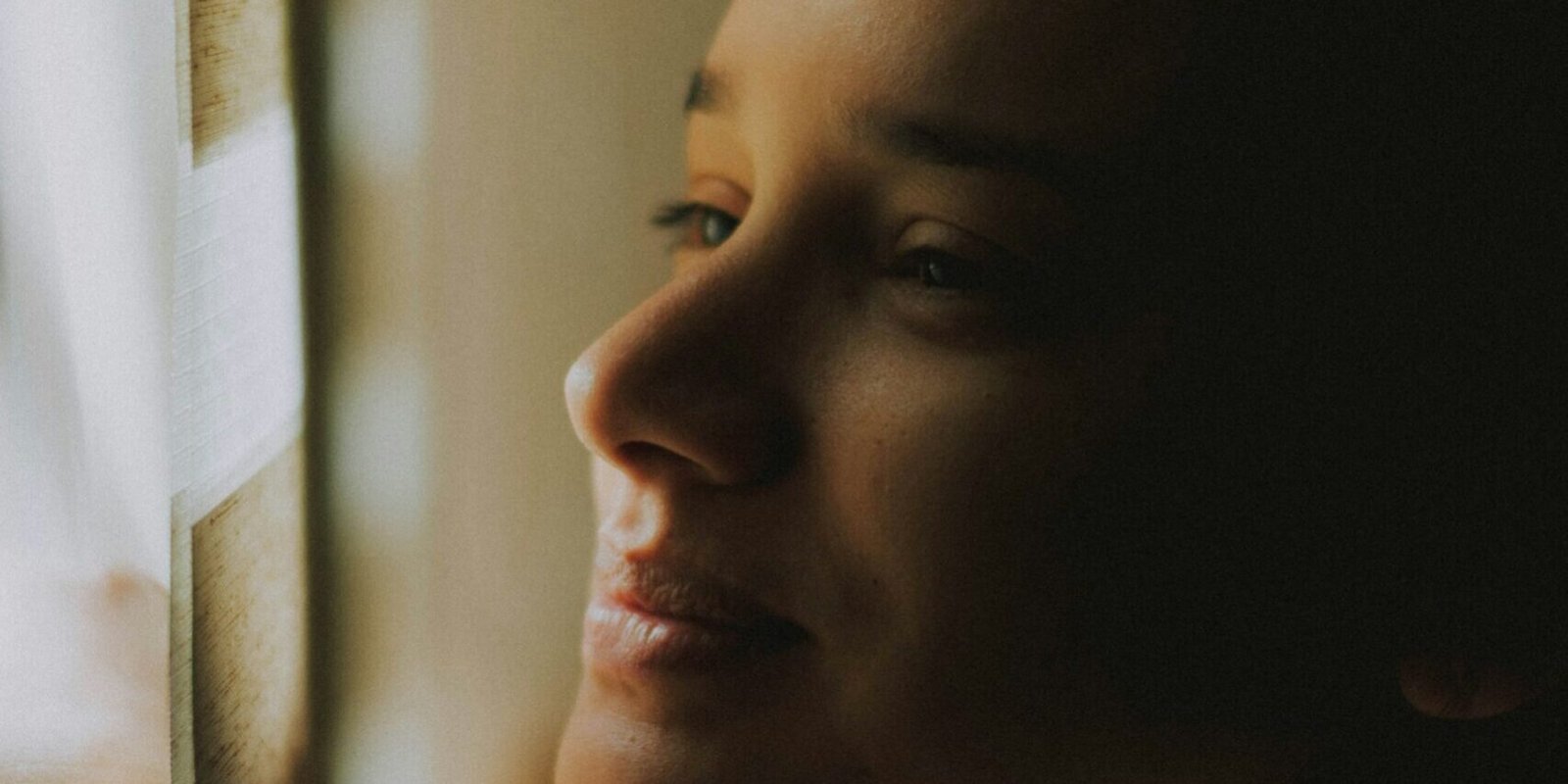 dating-after-divorce-woman-warm-light A woman smiling softly in warm indoor light.