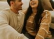 A couple laughing together, relaxed and at ease.