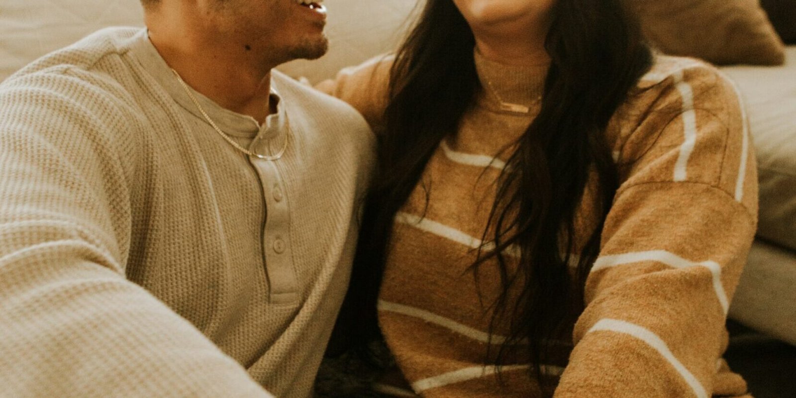 A couple laughing together, relaxed and at ease.