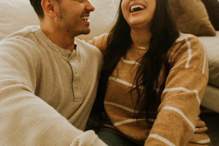 A couple laughing together, relaxed and at ease.