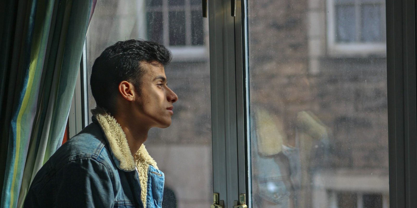 lose-interest-fear-of-intimacy-man-window A man looking out a window, withdrawn and pensive.