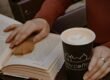 A woman reading with a cup of coffee, cozy and unhurried.