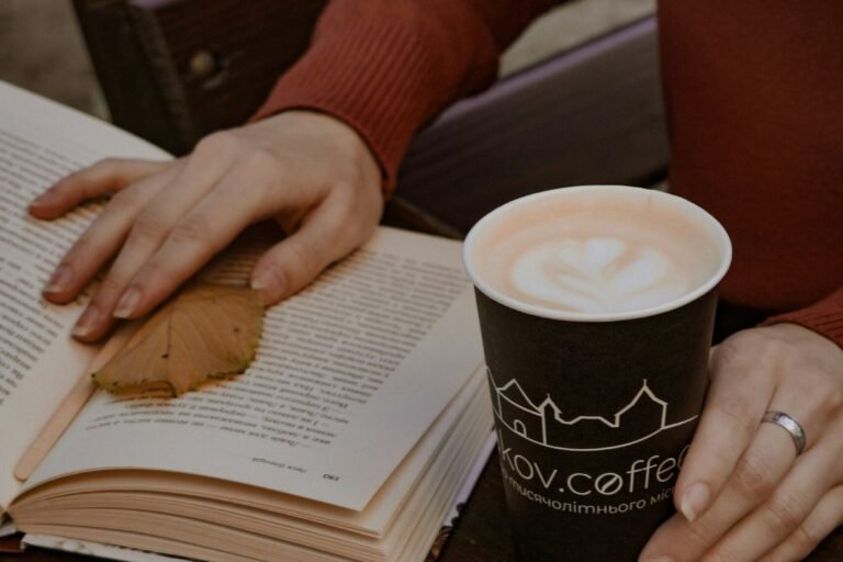 A woman reading with a cup of coffee, cozy and unhurried.