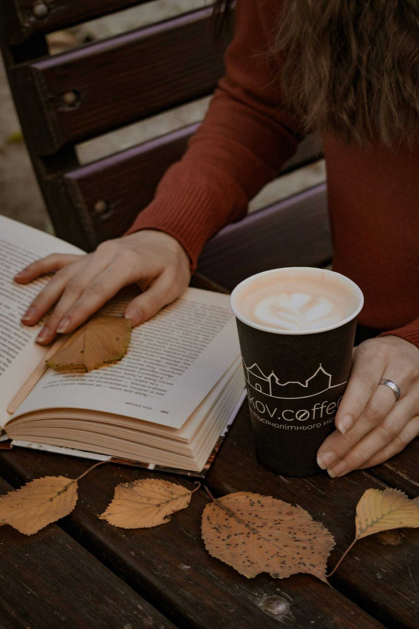A woman reading with a cup of coffee, cozy and unhurried.