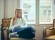 A woman sitting alone in an armchair, lost in thought.