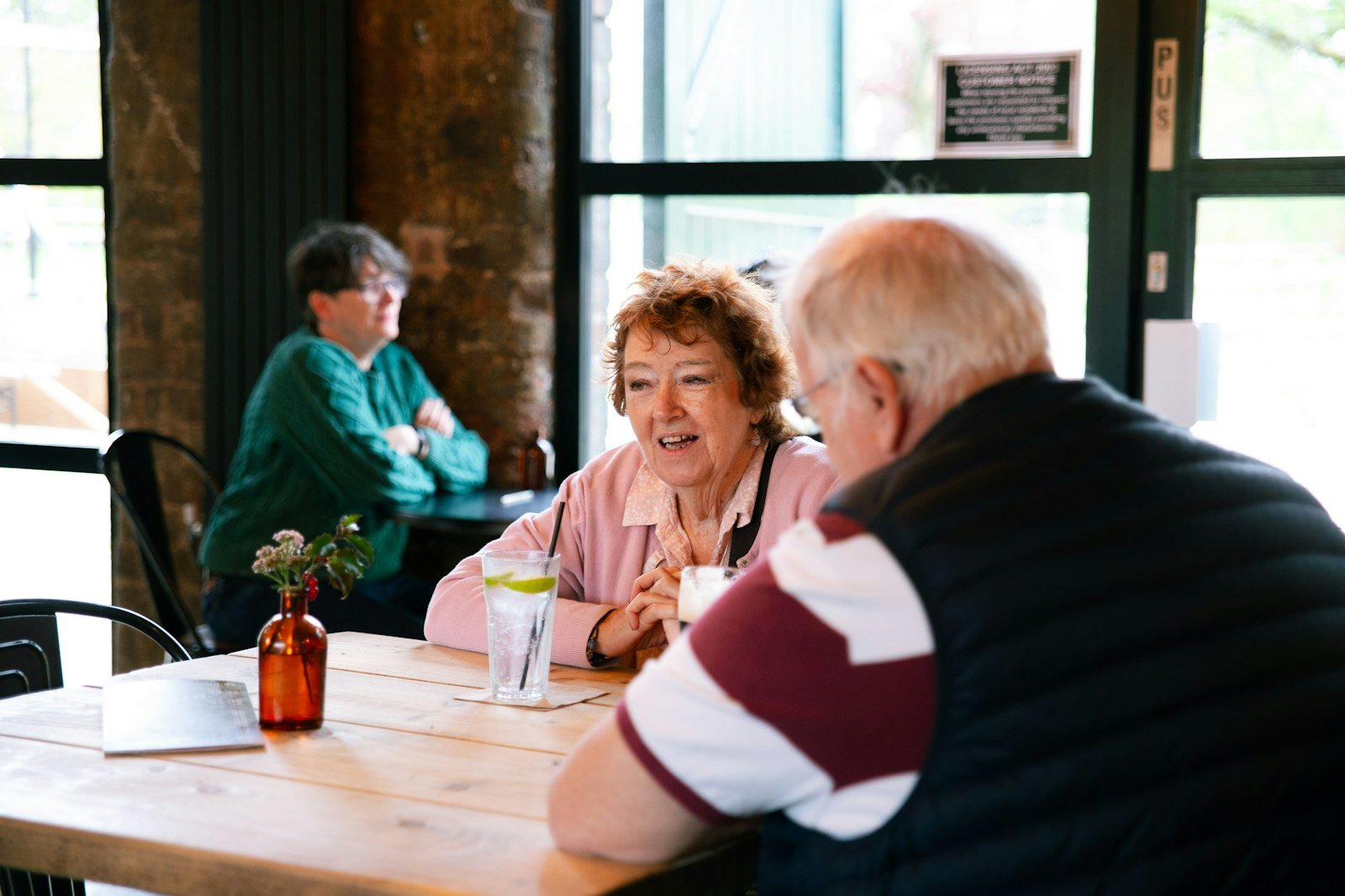 Two people relaxed and laughing on a first date arranged through matchmaking over 50.