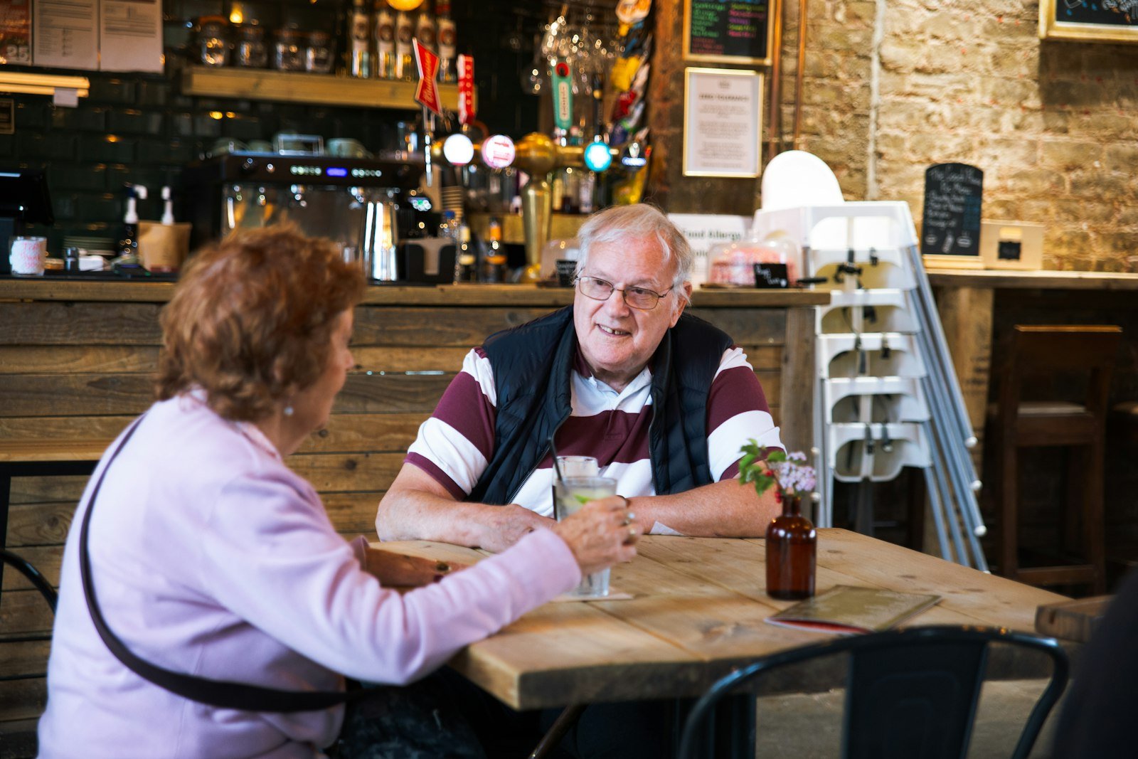 Two people talking across a small cafe table in Toronto.
